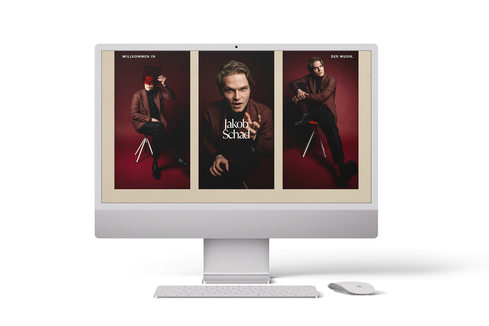 Ein Computerbildschirm zeigt eine Website mit drei Fotos eines Mannes im Anzug, der auf einem Hocker vor einem roten Hintergrund posiert. Auf dem mittleren Foto steht der Text Jakob Schaf. Vor dem Bildschirm befinden sich eine Tastatur und eine Maus.