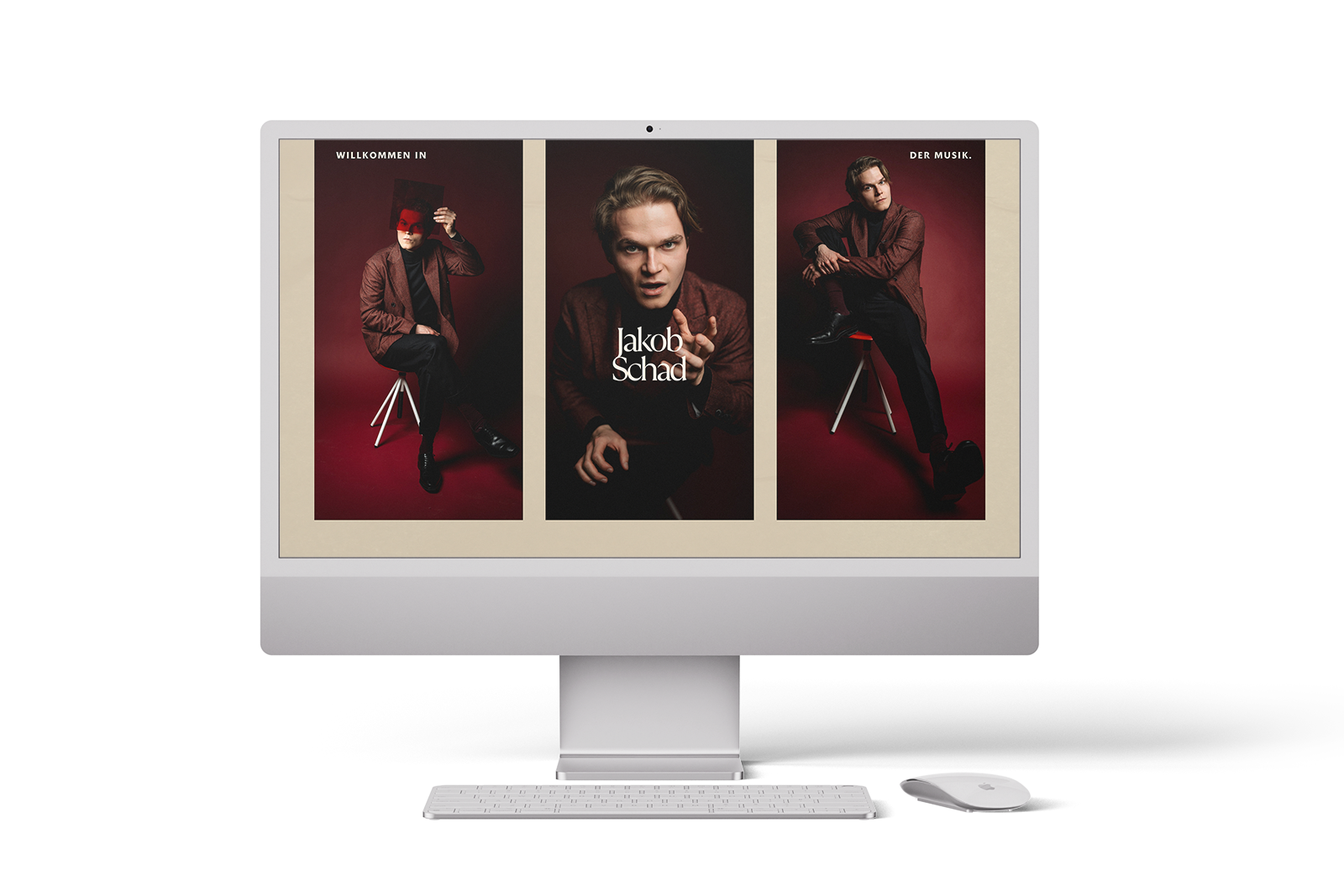 Ein Computerbildschirm zeigt eine Website mit drei Fotos eines Mannes im Anzug, der auf einem Hocker vor einem roten Hintergrund posiert. Auf dem mittleren Foto steht der Text Jakob Schaf. Vor dem Bildschirm befinden sich eine Tastatur und eine Maus.