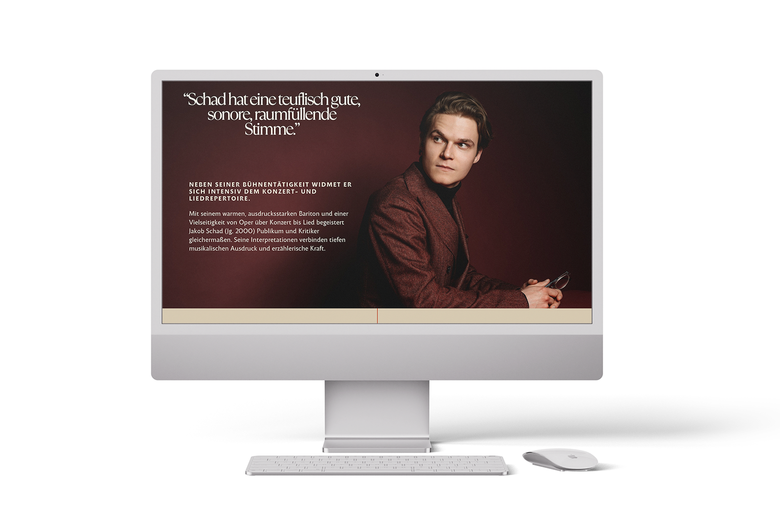 Auf einem Desktop-Computer wird eine Website angezeigt, auf der ein Mann in einem dunkelroten Anzug vor einem braunen Hintergrund sitzt. Auf dem Bildschirm erscheinen ein deutscher Text und ein Zitat über seine kräftige, klangvolle Stimme. Neben dem Computer befindet sich eine Maus.