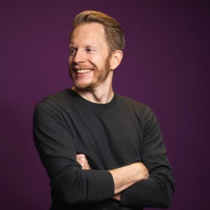 Ein Mann mit Bart lächelt.